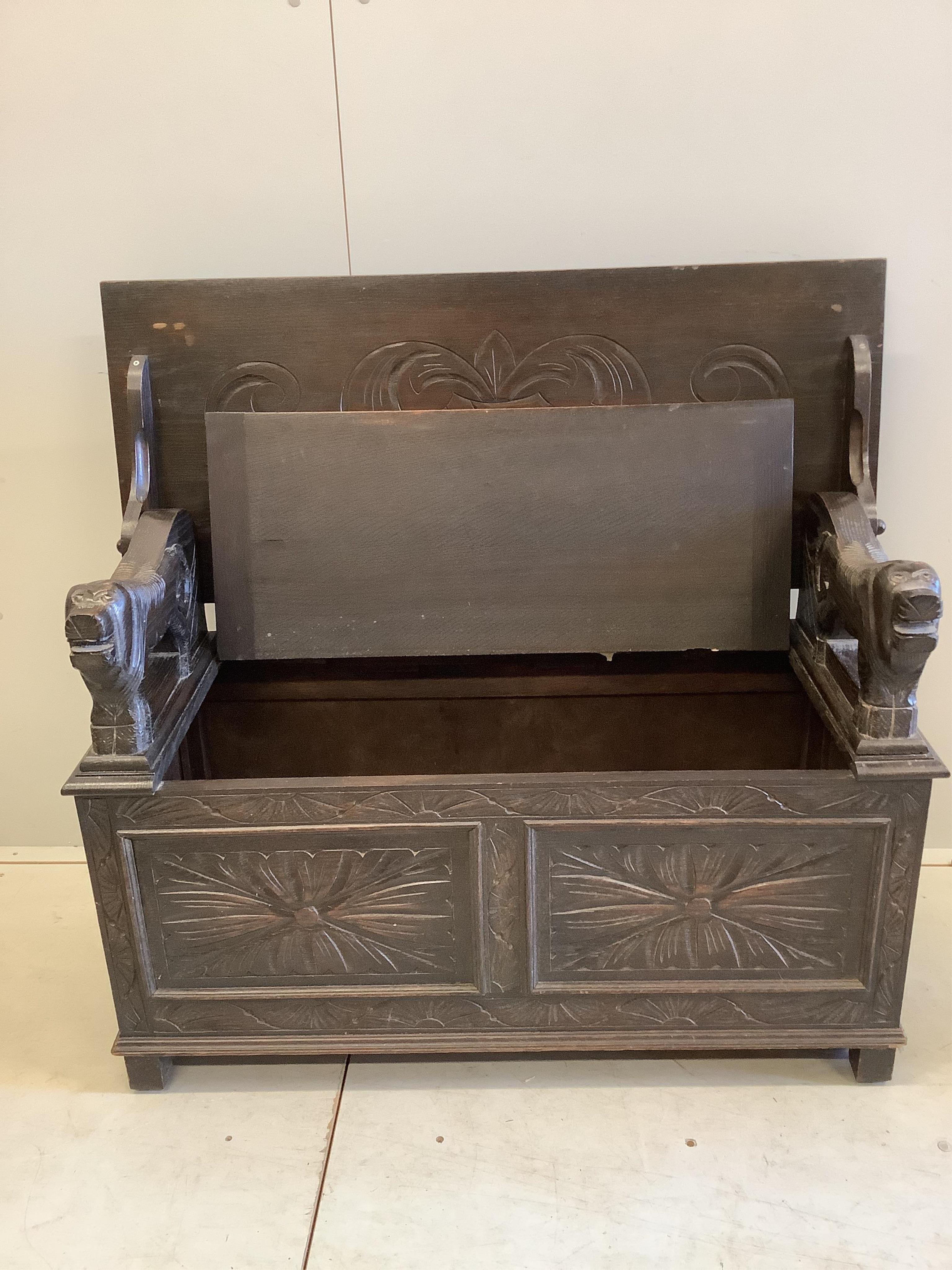An early 20th century carved oak monk's bench, width 107cm, depth 45cm, height 173cm